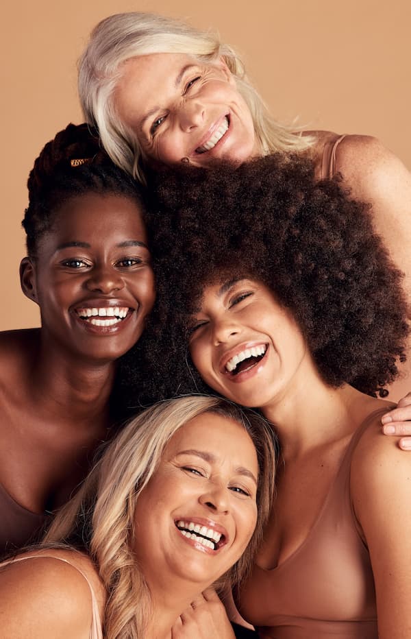 multiracial women laughing together with different skin tones